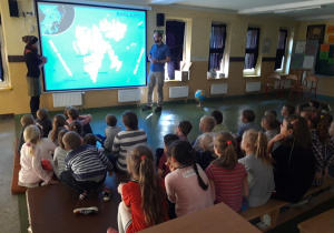 Dzieci oglądają prezentację prowadzoną przez gości.